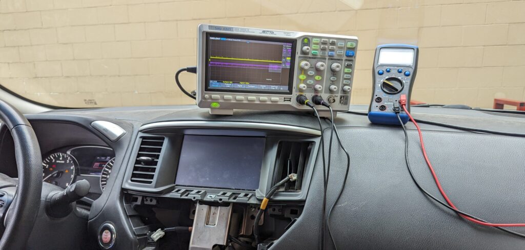 Photo of a Nissan Pathfinder Screen Not Working, with an oscilloscope diagnosing CAN Bus signals.
